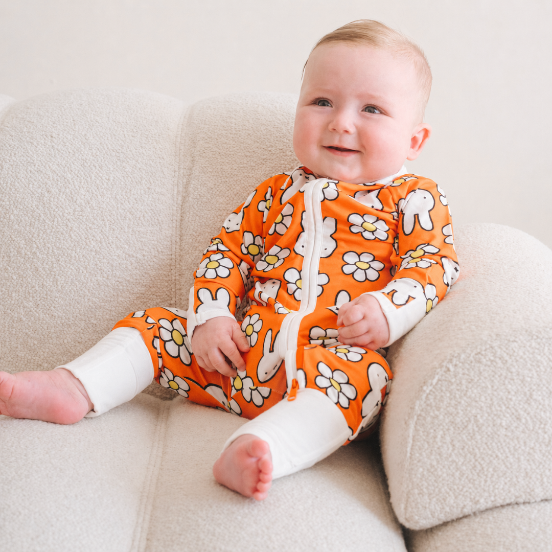 Baby wearing the ZIPSTER x Miffy Daisy Days bamboo babygrow